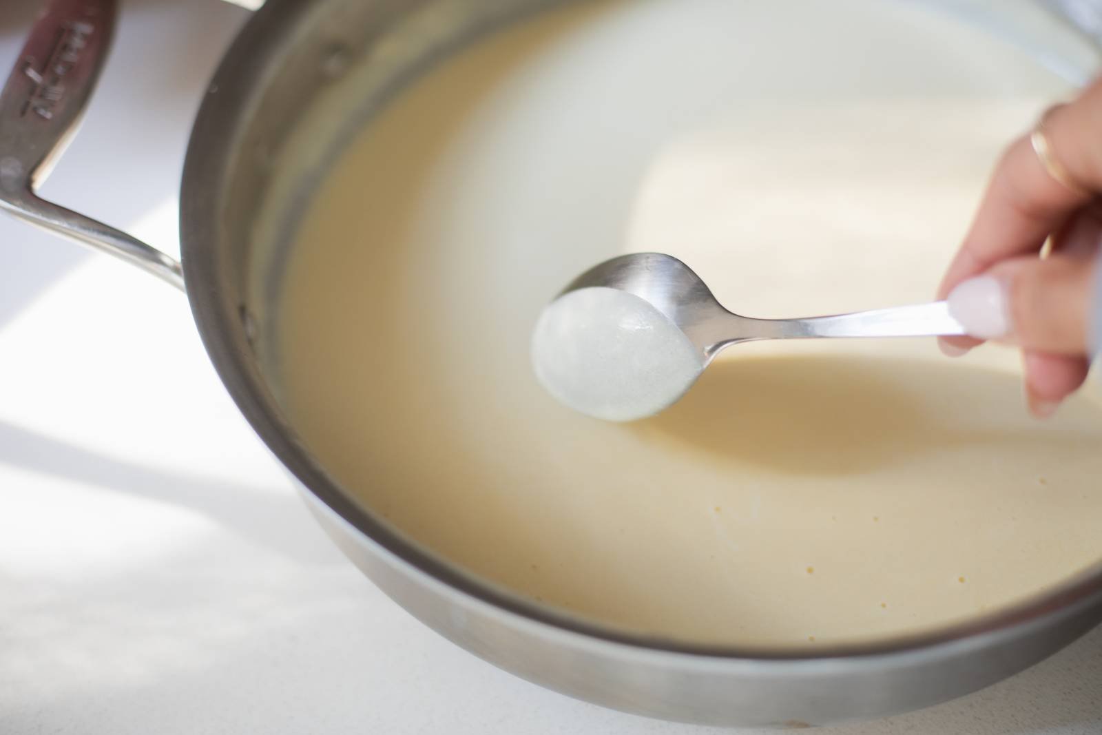 Coating Alfredo sauce on the back of a spoon.