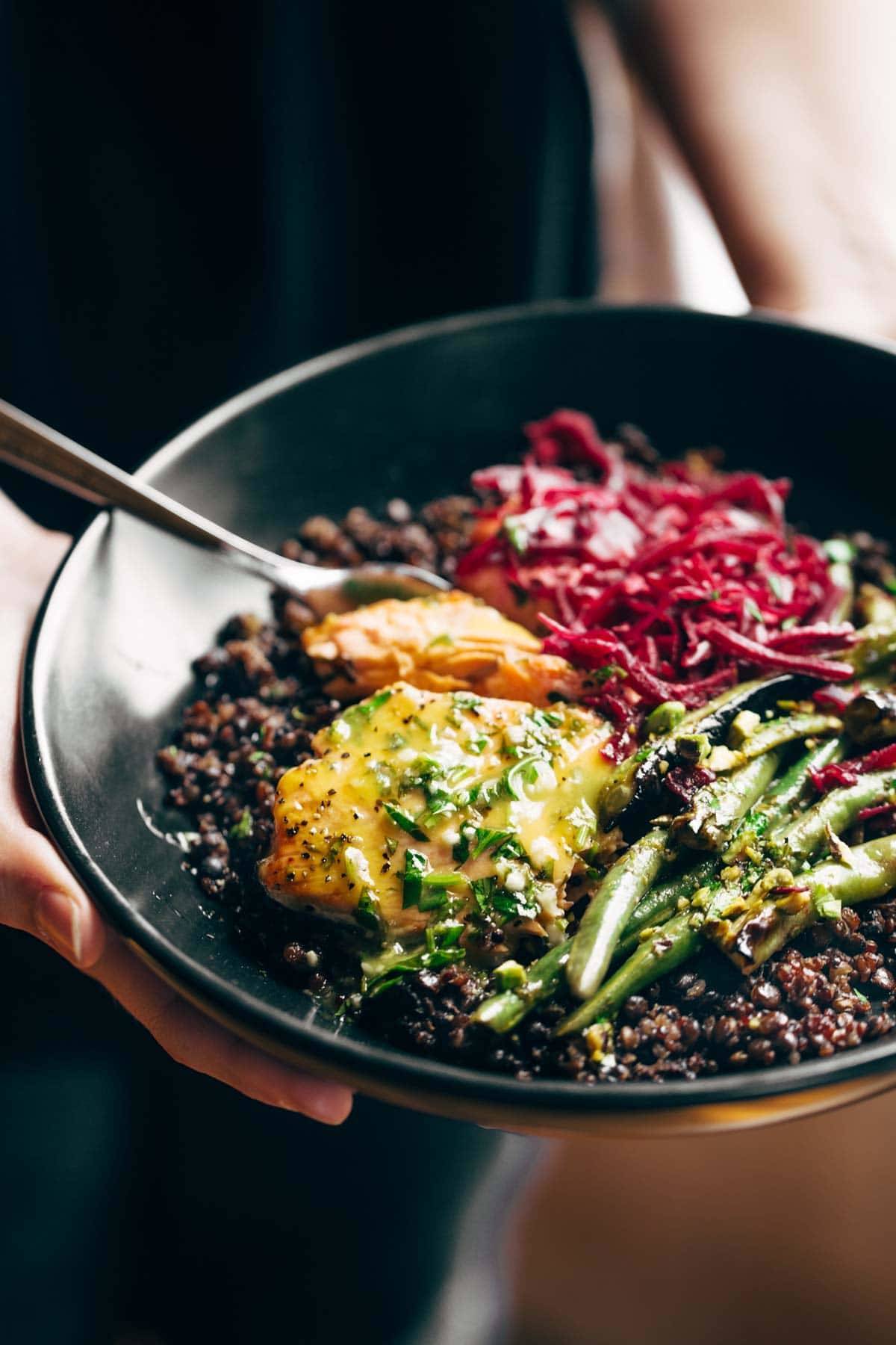 Bowl with salmon and lentils with a fork.