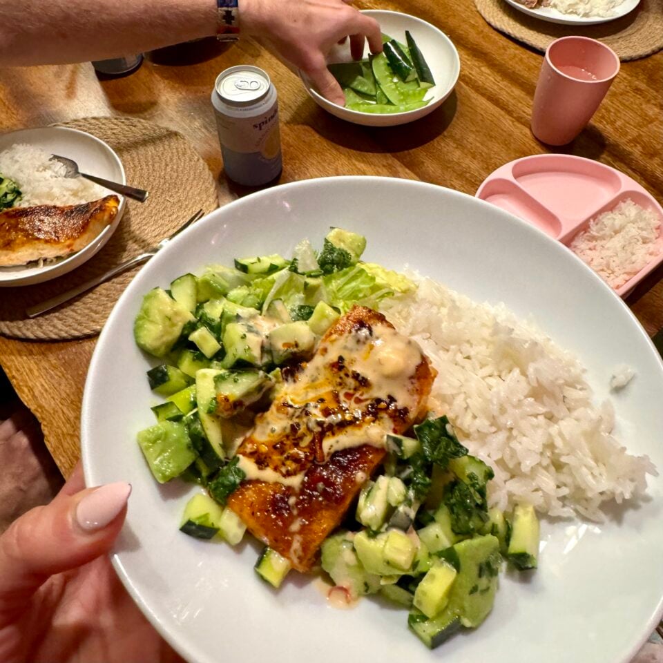 Bowl with rice, salmon, and cucumber avocado salsa.