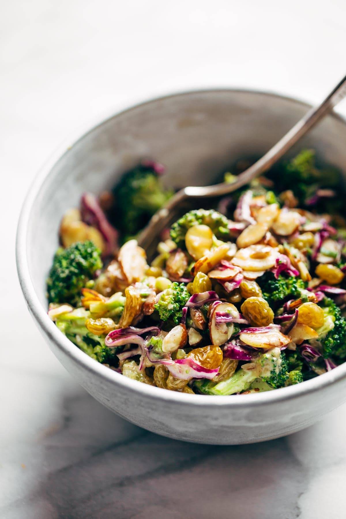 Broccoli salad in a bowl with a fork.