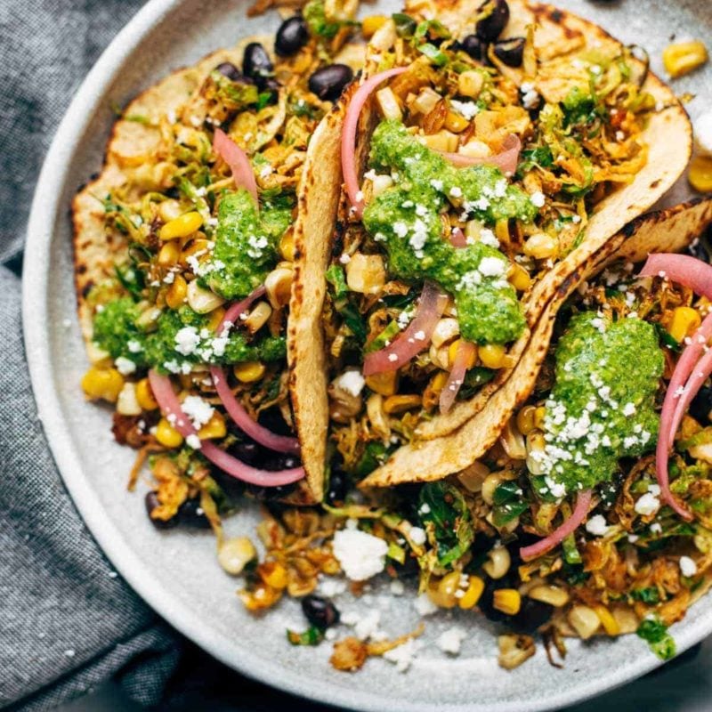 Brussels sprouts tacos on plate with toppings.