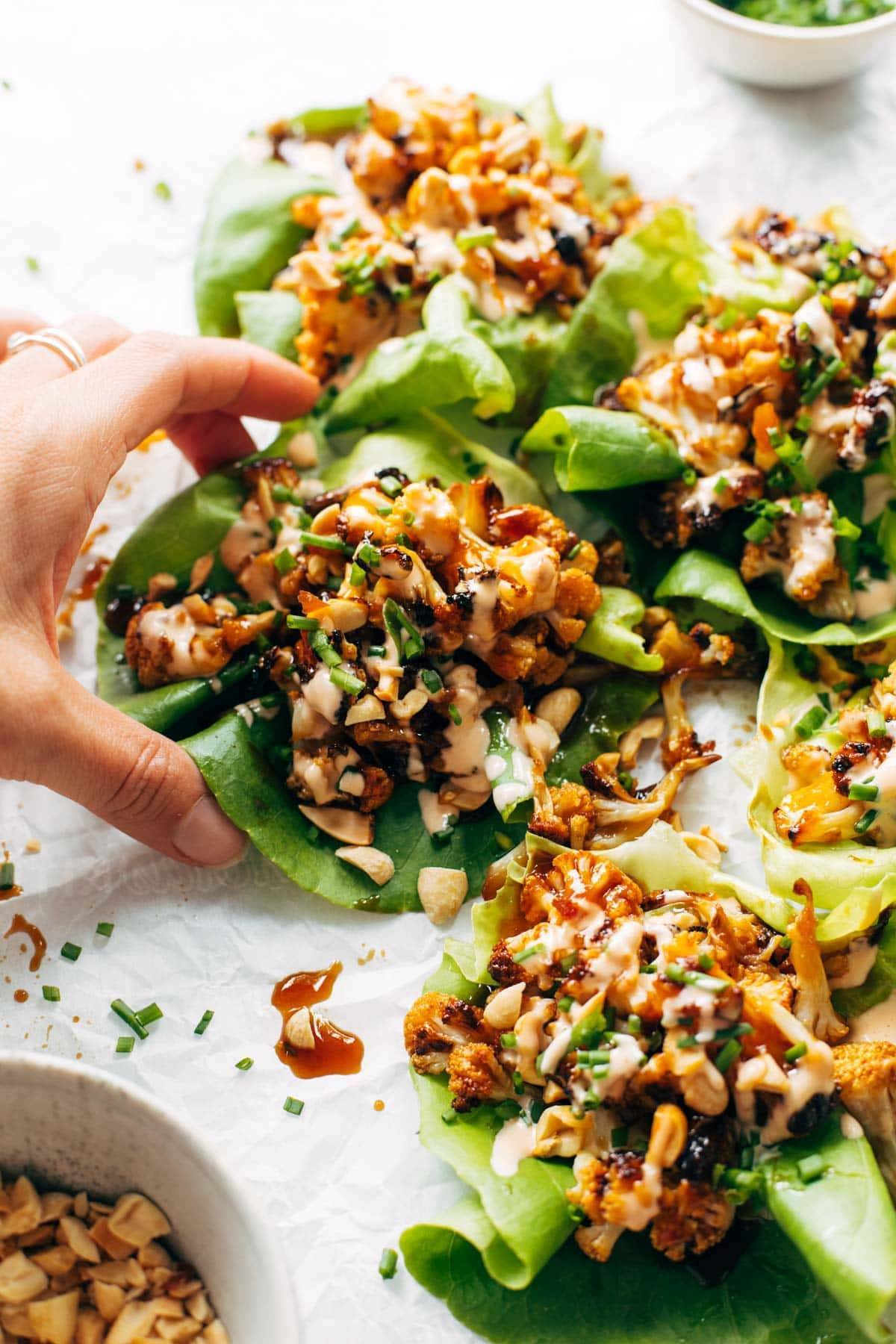 Cauliflower lettuce wraps with hand grabbing.