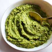 Cilantro pesto in a bowl with a spoon.