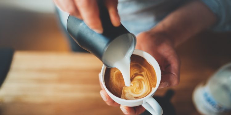 Milk pouring into fresh coffee