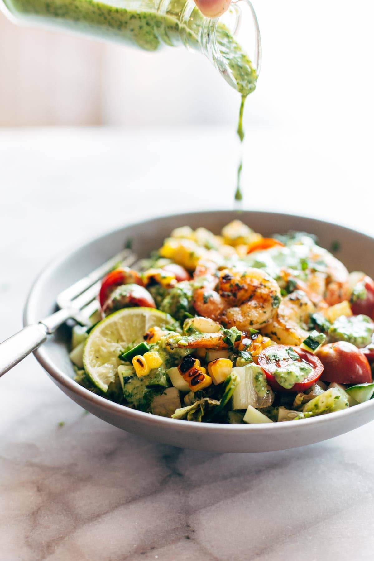 Salad in a bowl with a drizzle of cilantro dressing.