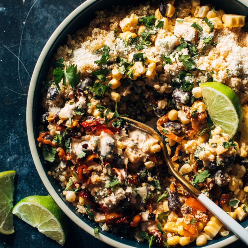 Elote quinoa salad in a bowl with cotija cheese and a fork