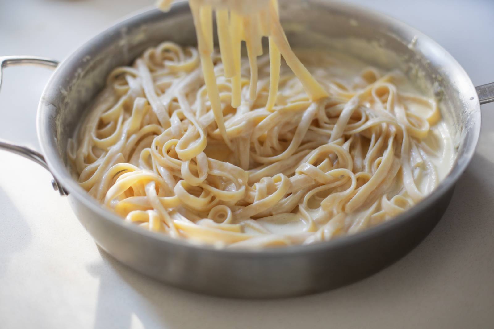 Finished fettuccine Alfredo sauce in a pan.