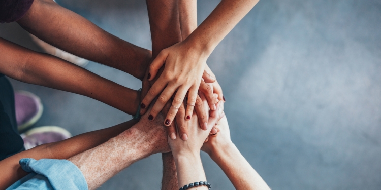 People from diverse backgrounds with their hands together