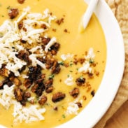 Pumpkin soup in a bowl with walnut crispies and a spoon!