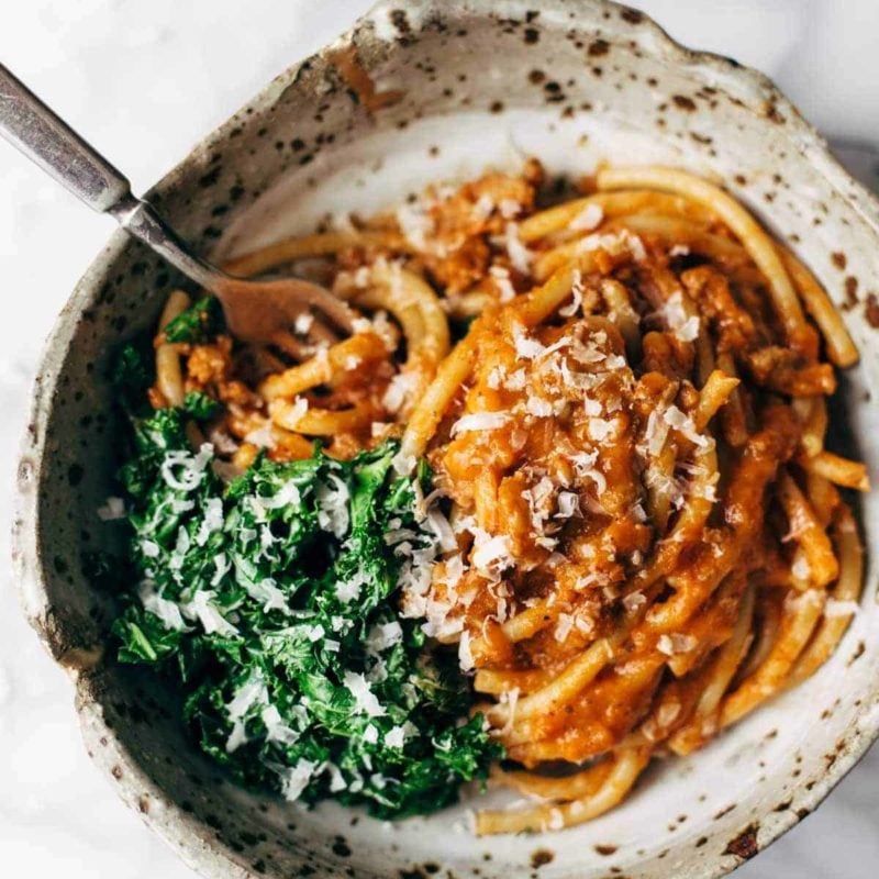 A fork in a dish of pumpkin spaghetti.