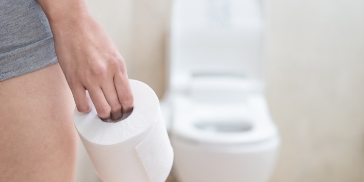 Person carrying toilet paper to a restroom