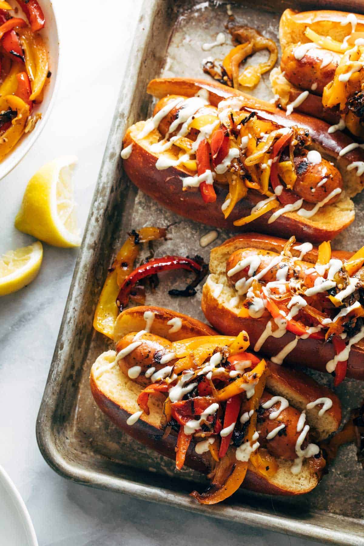 Grilled sausage and peppers with aioli on a sheet pan.