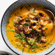 Sweet potato soup in a bowl topped with cauliflower crumbles.