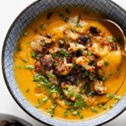 Sweet potato soup in a bowl topped with cauliflower crumbles.