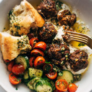 Meatballs in a bowl with a tomato salad and bread