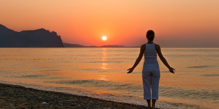 Woman on beach at sunrise